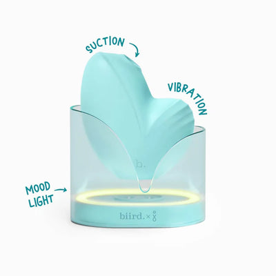 Mint green Biird Namii Jouissance Club Edition clitoral stimulator with suction, vibration, and mood light charging base.