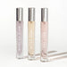 Set of three Eye of Love pheromone perfumes in slender glass bottles with silver caps, labeled Morning Glow, After Dark, and One Love.