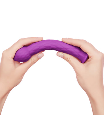 Hands bending a textured purple silicone wand designed for targeted stimulation and comfort.