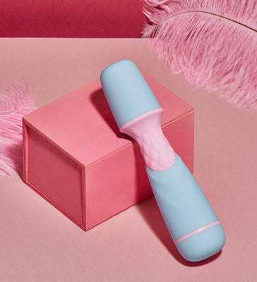 Compact Femme Funn Ffix Mini Wand vibrator in pastel blue and pink on a pink box with feather accents