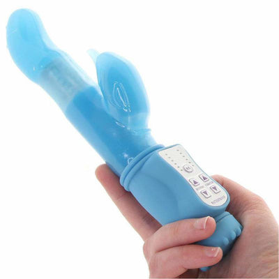 Hand holding a blue rotating rabbit vibrator with control buttons and a curved tip.