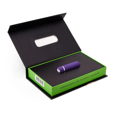 Purple compact bullet vibrator displayed in an open black and green box with "harmonious and blissful pleasure" text.