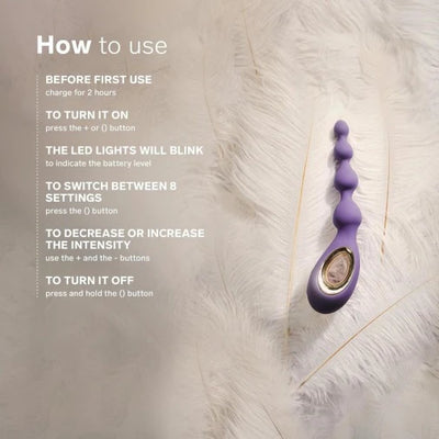 Lelo Soraya Anal Beads in purple with instructions on charging, power, and intensity controls on a soft white fur background.