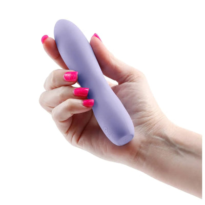 Hand holding a compact lavender silicone vibrator with a smooth, rounded tip and discreet control buttons.