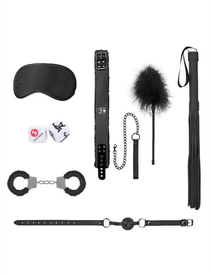 Introductory bondage kit with black satin mask, leather collar with leash, feather tickler, flogger, furry handcuffs, ball gag, and sex dice.