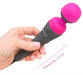 Hand holding Palmpower Massager with pink silicone head and ergonomic curved black handle against white background.