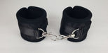 Pair of black neoprene wrist restraints with adjustable straps and metal lobster clasp connection.