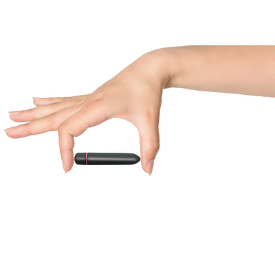 Hand holding a compact black waterproof bullet vibrator with a pink accent ring against a white background.