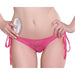 Close-up of a woman wearing pink lace tie-side panties holding a white remote control for a rechargeable vibrating panty.