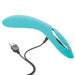 Teal curved silicone vibrator with ergonomic design and USB charging cable connected, featuring three control buttons.