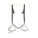 Black adjustable door swing with padded seat and stirrups hanging over a white door with silver handle.