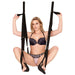 Woman demonstrating the Adam & Eve Naughty Couples Door Swing with adjustable black straps and padded stirrups.