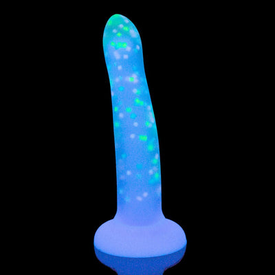 Glow-in-the-dark silicone pleasure toy with confetti pattern and suction cup base against black background