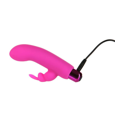 Pink rechargeable bullet vibrator with removable silicone rabbit sleeve and USB charging cable attached.