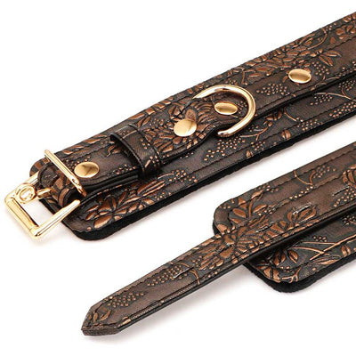 Close-up of brown floral print PU ankle restraints with gold hardware and soft black faux fur lining.