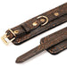 Close-up of brown floral print PU ankle restraints with gold hardware and soft black faux fur lining.