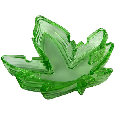Stack of green translucent glass ashtrays shaped like a stylized leaf with notches for resting smoking items.