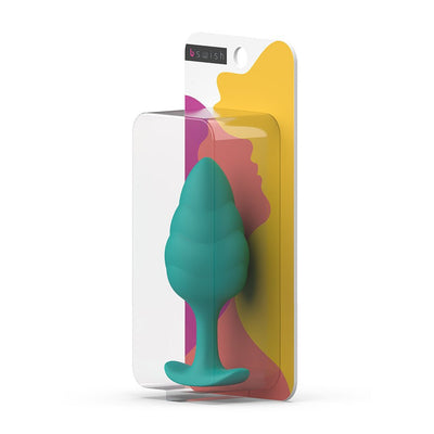 Seafoam green silicone plug with wave texture in clear retail packaging with colorful abstract background.