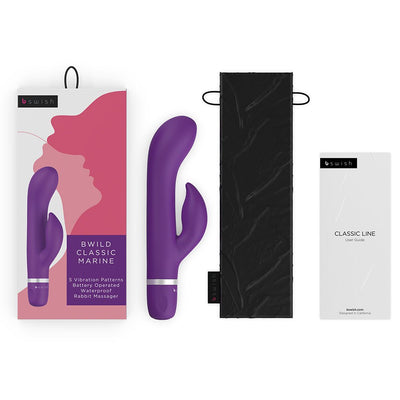 Purple B Swish Bwild Classic Marine vibrator with packaging, black storage pouch, and user guide on white background.
