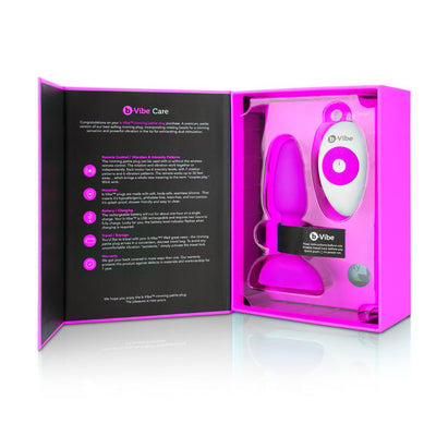B-Vibe Rimming Petite Plug in pink with wireless remote control displayed in open branded packaging box.