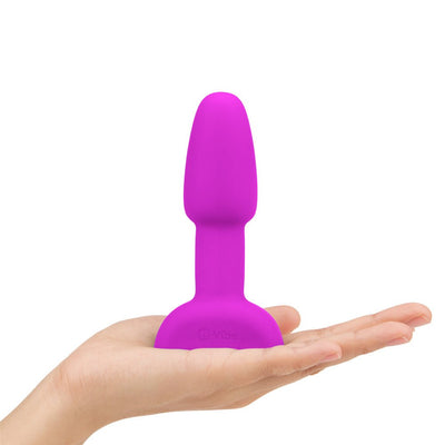 Hand holding a compact, purple silicone B-Vibe Rimming Petite Plug designed for beginner anal stimulation.