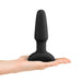 Hand holding a black silicone B-Vibe Rimming Plug 2 with a tapered shape and flared base.