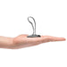 Hand holding a polished stainless steel prostate plug with a curved, textured design and wide base.