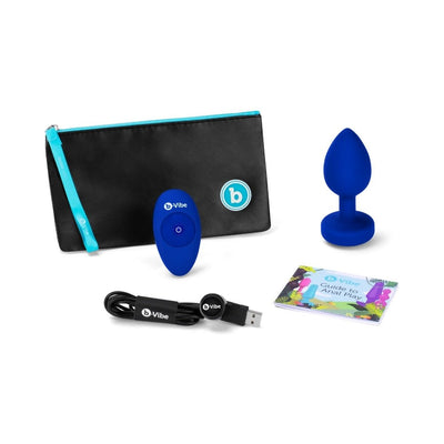 Blue sapphire vibrating plug with remote, USB charging cable, guide booklet, and black storage pouch with blue zipper.