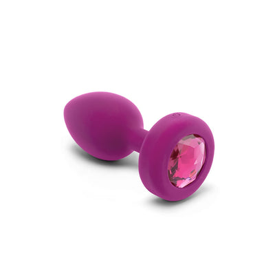 Purple silicone vibrating plug with a pink jewel base and remote control power button.