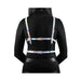 Back view of a person wearing a rainbow-colored adjustable chest harness with rose gold buckles over a black long-sleeve top.