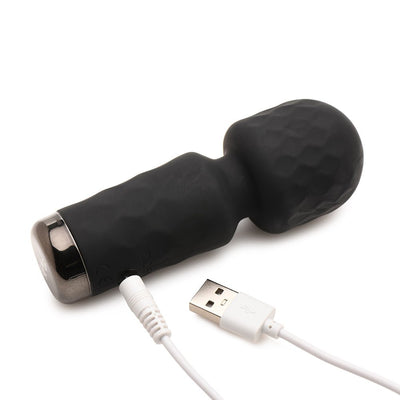 Compact black silicone mini wand vibrator with textured head and USB charging cable on white background.