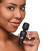 Close-up of a woman holding a black BANG! 10X Vibrating Mini Wand with a flexible neck against a white background.