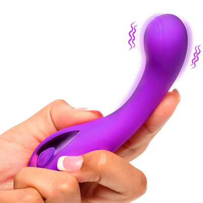 Hand holding a purple curved silicone G-spot vibrator with a rounded, ribbed head and vibration motion lines.