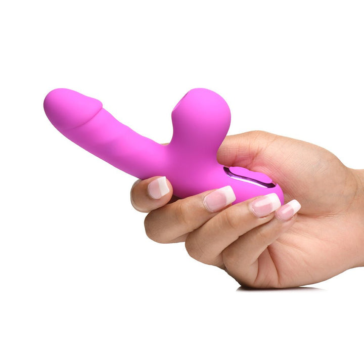 Hand holding a pink mini rabbit vibrator with curved clit suction arm and smooth shaft on white background.