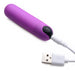 Purple vibrating bullet with black power button connected to a white USB charging cable on a white background.