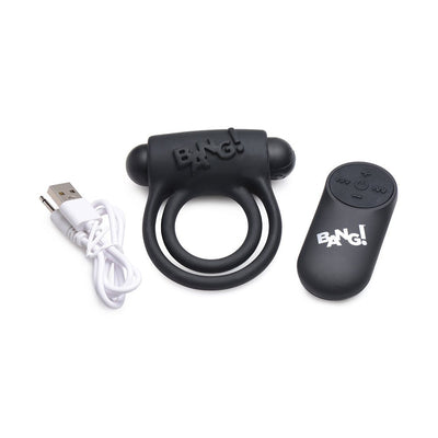 Black silicone vibrating cock ring with remote control and USB charging cable on white background.