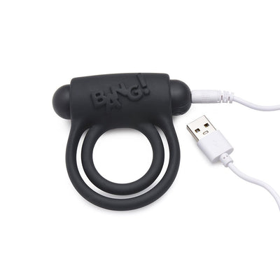 Black silicone vibrating cock ring with dual rings and USB charging cable on white background