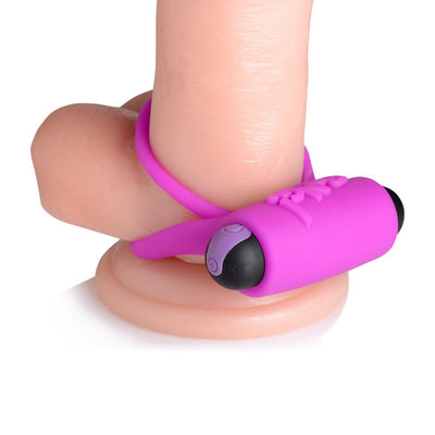Purple silicone vibrating cock ring with bullet and remote control displayed on a realistic model.