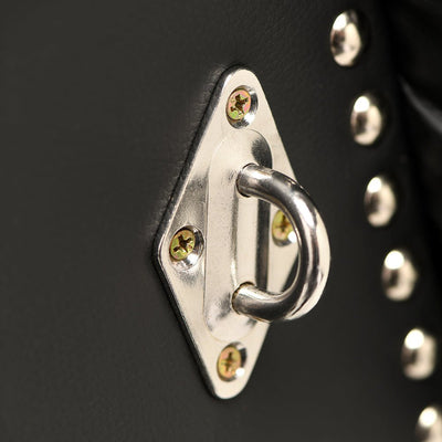 Close-up of metal attachment ring on black vegan leather bondage bench with decorative studs.