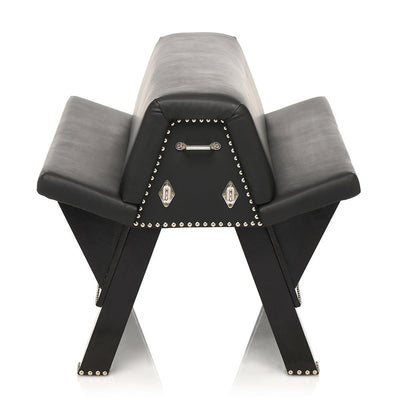 Black faux leather bondage bench with padded angled cushions, metal studs, and multiple attachment points for restraints.