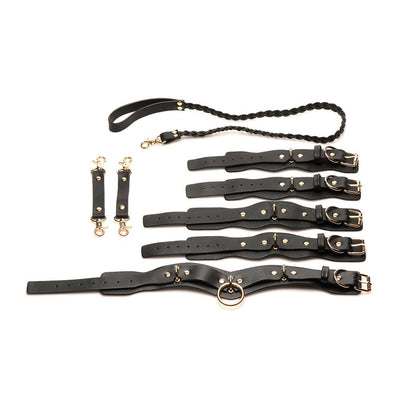 Black vegan leather lovers restraint set with adjustable wrist and ankle cuffs, collar with braided leash, and gold hardware connectors.