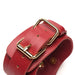 Close-up of red vegan leather adjustable strap with gold buckle and hardware detail.