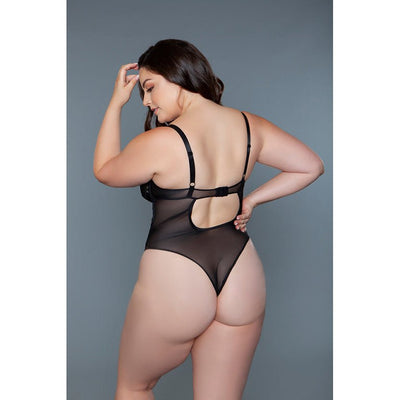 Plus size model wearing black sheer mesh bodysuit with adjustable straps and back cutout detail against gray background