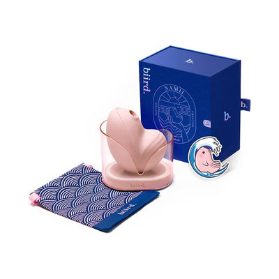 Biird Namii clitoral stimulator in soft pink with charging base, blue storage pouch, and branded packaging box.