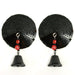 Pair of round black sequin pasties with dangling black bells and red bead accents on white background.