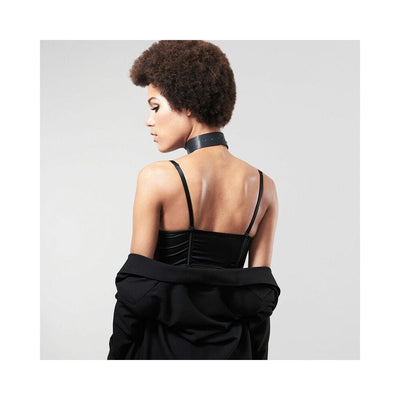 Woman wearing a black vegan leather Maze choker with leash, styled with a black top and jacket draped off shoulders.