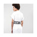 Woman wearing a white dress styled with Bijoux Indiscrets Maze wide black vegan leather belt restraints at the waist.