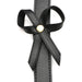 Close-up of black PU leather strap with stitched edges and decorative bow secured by a gold-tone metal rivet.