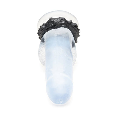 Black silicone cock ring shaped like a grinning caiman wrapped around a clear model shaft.