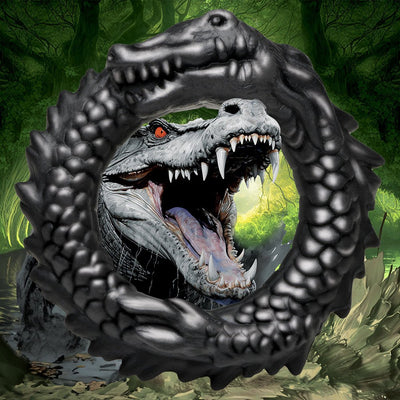 Black silicone cock ring shaped like a grinning caiman with textured ridges and bumps, set against a swamp background.